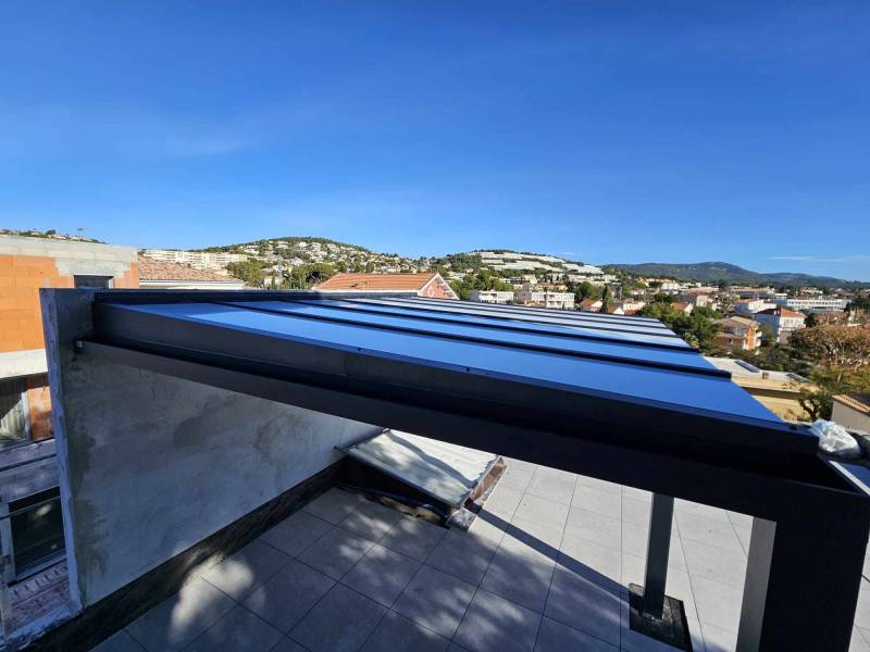 Réalisation d'une pergola en polycarbonate adossée à un mur sur un toit terrasse