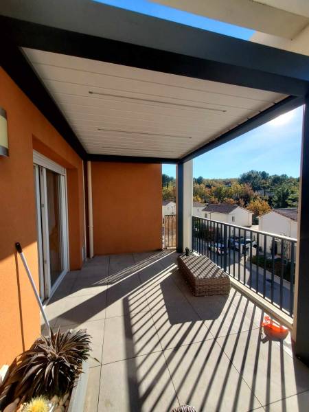 Aménagement d'une terrasse d'appartement avec une pergola bioclimatique adossée au mur à Eguilles