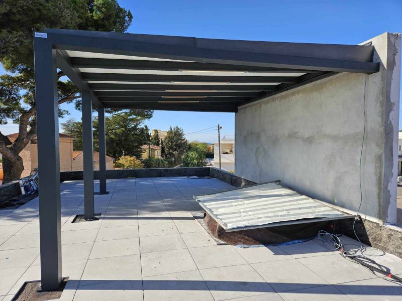 Réalisation d'une pergola en polycarbonate adossée à un mur sur un toit terrasse