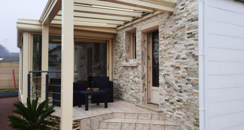 Réalisation d'une petite pergola vitrée sur mesure couleur sable adossée à une maison en pierre à Roquefort-la-Bédoule près de Marseille