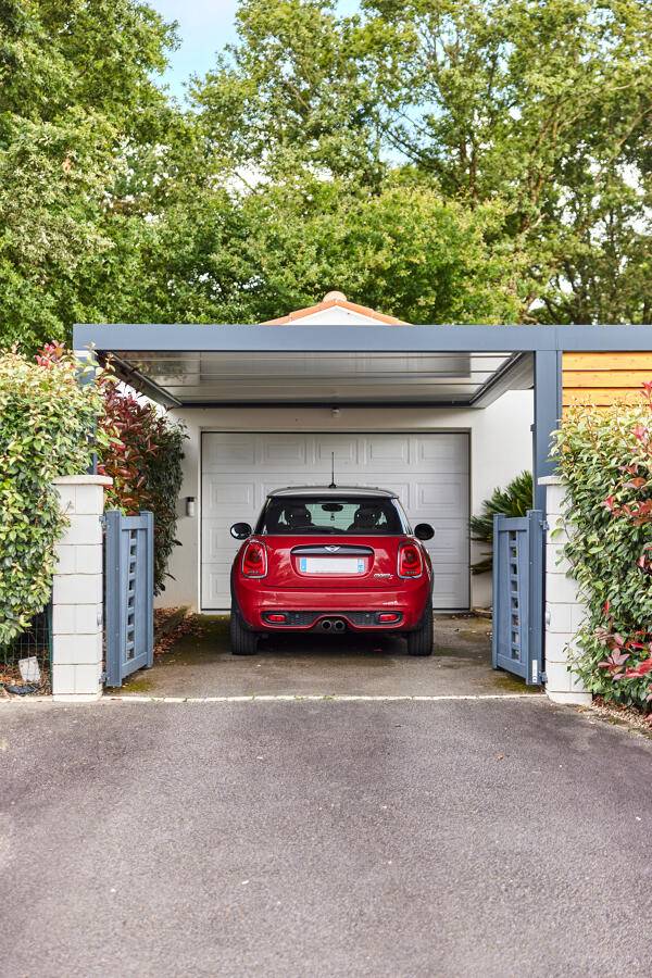 Carport adossé gris anthracite protégeant un véhicule dans un jardin à Saint-Maximin-la-Sainte-Baume