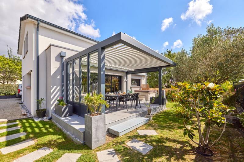Pergola bioclimatique en aluminium gris anthracite à lames orientables, paroi vitrée et départ vitré à Marseille